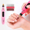 Une personne utilise le kit de manucure 6 en 1 Fashiongirl Electric Nail File de couleur rose sur ses ongles, avec les forets et les bandes abrasives inclus affichés à côté de l'outil.