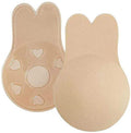 Les coussinets Shapelux Lifting Pads for Invisible Breast Lift sont des coussinets en silicone beige réutilisables en forme d'oreilles de lapin et dotés d'un ruban adhésif puissant. L'un présente une face avant lisse, l'autre révèle des découpes en forme de cœur et un adhésif texturé pour remplacer un soutien-gorge sans bretelles.