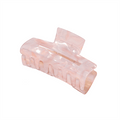 La pince à cheveux SOHO Aria Hair Claw - Blush est une pince à cheveux rectangulaire en acétate rose translucide avec des dents entrecroisées et un design incurvé, présentée sur un fond blanc.