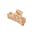 La pince à cheveux SOHO Aria - Champagne de SOHO présente un design rectangulaire aux bords incurvés en acétate marbré beige et marron clair, créant un accessoire chic pour les cheveux présenté sur un fond blanc.