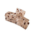 La pince à cheveux SOHO Aria - Light Tortoise présente un design en acétate beige et marron écaille avec des bords incurvés et des dents emboîtables, fabriquée par SOHO pour maintenir fermement les cheveux épais en place.