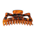La pince à cheveux SOHO Astrid Hair Claw - Tortoise de SOHO est une pince solide à motif écaille de tortue, dotée de dents entrecroisées et d'une charnière à ressort, conçue pour maintenir en place les cheveux épais tout au long de la journée.