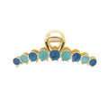 La pince à cheveux SOHO Becca Hair Claw - Ocean de SOHO présente un design en métal doré avec des pierres rondes bleues et turquoise alternées sur le bord, idéale pour maintenir votre coiffure.