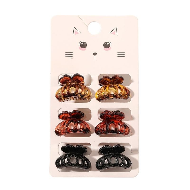 The SOHO Fika Mini Hair Claws by SOHO include six small claws in yellow, brown, and black—arranged in pairs on a card with a cute cat face illustration—perfect for daily hair styling.
