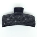 La pince à cheveux SOHO Hair Claw de SOHO est un accessoire pour cheveux en plastique noir avec un fermoir rectangulaire à texture quadrillée, présenté sur un fond blanc uni.