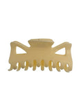 La pince à cheveux SOHO Hair Claw, de couleur blanc crème, avec des dents entrecroisées et des découpes triangulaires, est présentée sur un fond blanc.