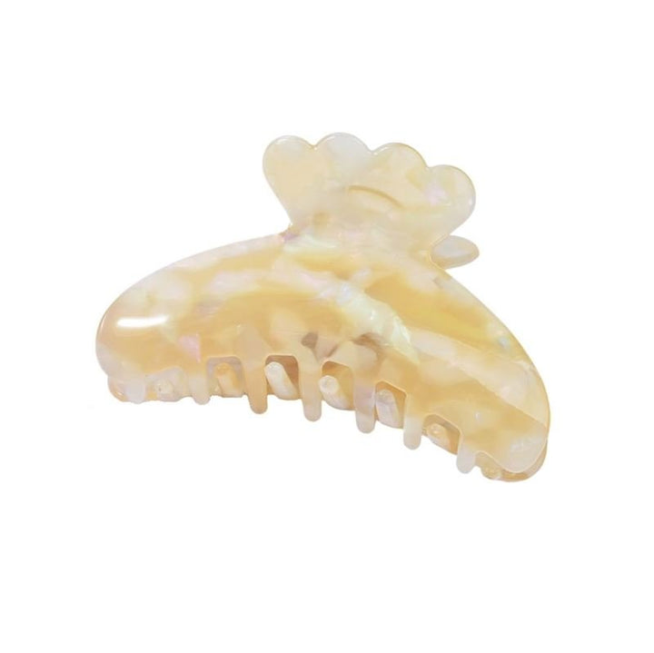 The SOHO Joy Hair Claw - Egg Nog by SOHO features pearlescent light yellow acetate with a curved, scalloped design, interlocking teeth, and a subtle marble sheen.