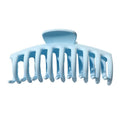 La pince à cheveux SOHO Kana Hair Claw en bleu clair est dotée de dents larges et incurvées pour une prise solide et convient à tous les types de cheveux. Présentée sur fond blanc.