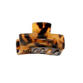 La mini-barrette SOHO Leia - Tortoise de SOHO présente un motif écaille de tortue marron, un design incurvé et des dents qui s'emboîtent pour une tenue sûre. Elle est parfaite comme petite barrette pour faciliter le coiffage et maintenir les cheveux en place.