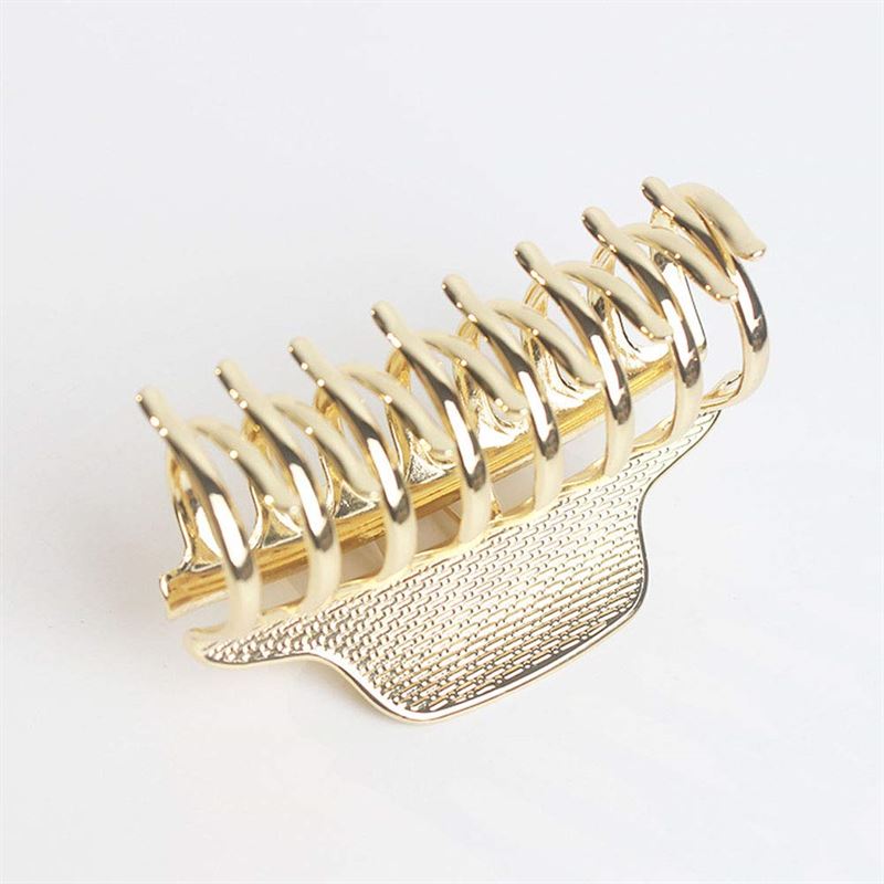 The SOHO London Metal Hair Claw in gold by SOHO features interlocking prongs and a textured grip for secure, stylish hold. Shown against a plain white background, it’s both practical and elegant.