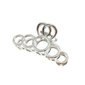 Sept anneaux métalliques brillants de différentes tailles, inspirés des courbes élégantes de la pince à cheveux SOHO Metal Hair Claw - Silver de SOHO, sont disposés en ligne comme une chenille sur un fond blanc.