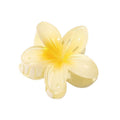 La barrette SOHO Moana Hair Claw - Yellow est un accessoire pour cheveux de couleur jaune clair en forme de fleur, avec cinq pétales brillants et un fermoir à ressort, inspiré de la fleur de frangipanier. Idéal comme accessoire estival.