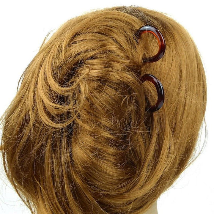 Gros plan sur l'arrière de la tête d'une personne aux cheveux châtain clair coiffés en torsade, soigneusement fixés à l'aide d'un lot de 3 épingles à cheveux SOHO Twist Chignon.