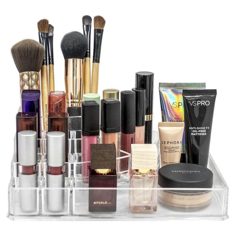 The UNIQ Acrylic Make Up Organiser 8 Compartments (ctn 07) by UNIQ holds and neatly arranges brushes, lipsticks, foundation tubes, compact powders, and small bottles in separate sections for easy access.