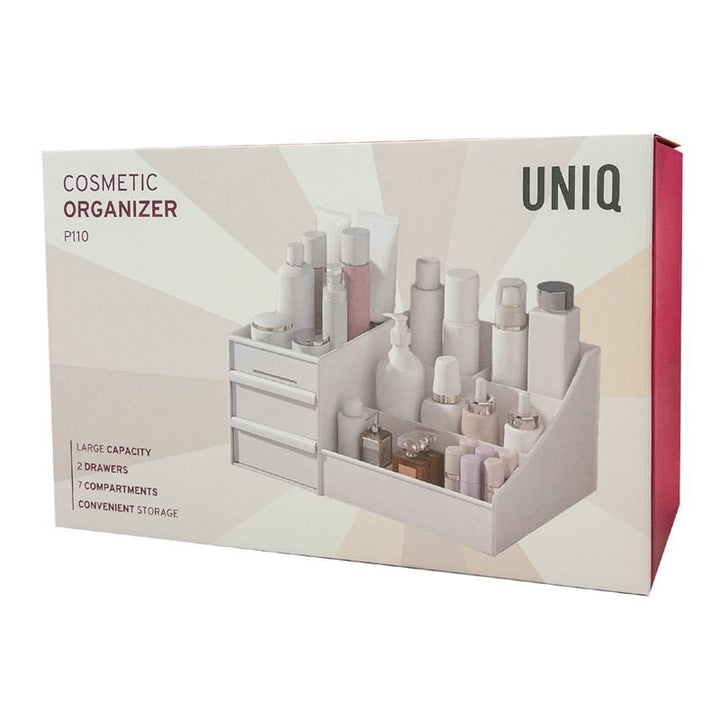A box labeled UNIQ Cosmetic Organiser with Two Drawers, White - P110 shows a white organiser by UNIQ with 2 drawers and 7 compartments filled with bottles—highlighting its large capacity, perfect for makeup storage.