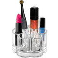 L'organiseur acrylique pour maquillage UNIQ Flower - U301 de UNIQ comporte plusieurs compartiments pour ranger des articles tels que du rouge à lèvres rose, un pinceau applicateur, du gloss orange, du vernis à ongles et un flacon de vernis à ongles bleu. Cet organiseur élégant se détache sur un fond blanc.